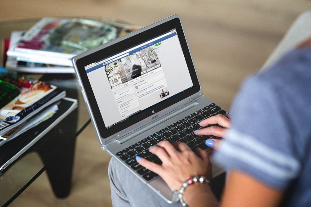 Facebook uses new tech to remove bad content Woman working on silver laptop with Facebook on screen
