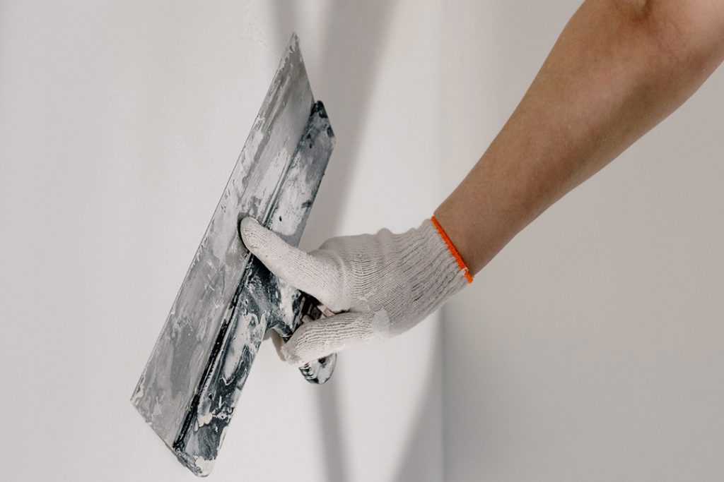 man finishing drywall to quality level